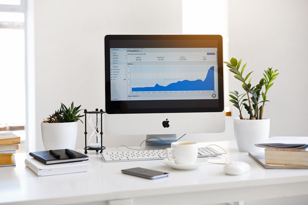 who-we-are A clean, contemporary workspace featuring a desktop with analytics on the screen and plants for a fresh look.